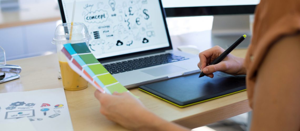 Close-up of female executive working over graphic tablet at her desk in office