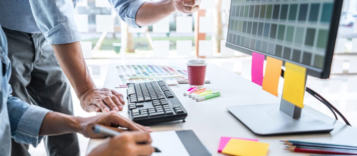 Young colleagues designers working together on a creative project and color samples for selection, Color swatch samples, Brainstorming Planning Partnership, creative graphic design working desktop.